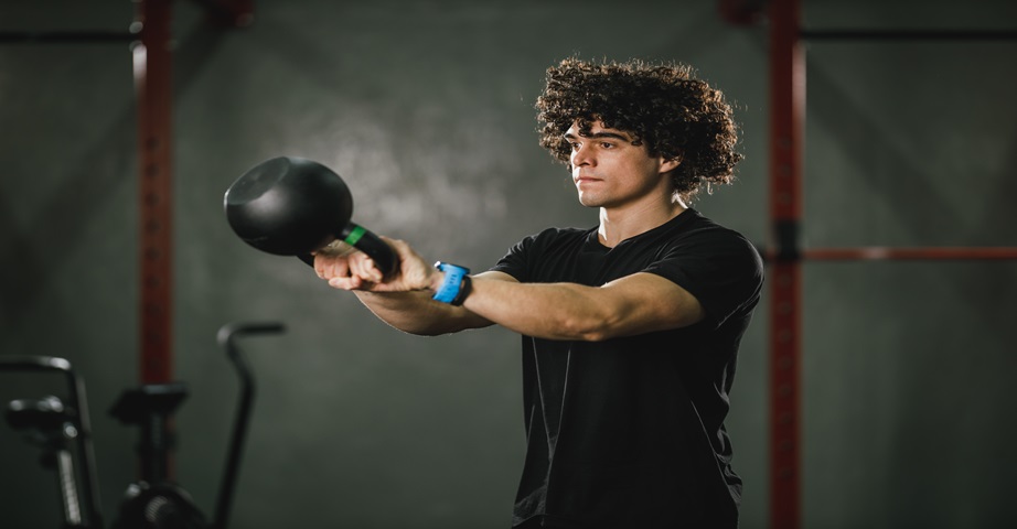 Mężczyzna wykonuje ćwiczenie na biceps z kettlebell - swing