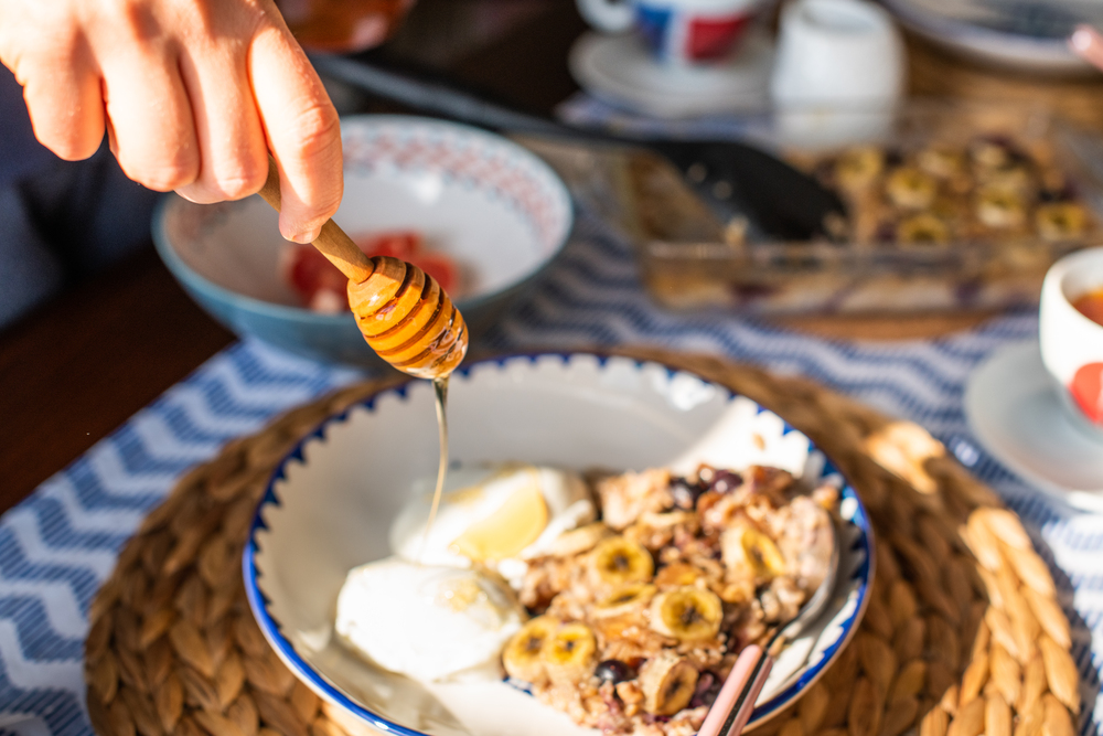 owsianka-na-stole-ktoś-dodaje-miód-manuka-do-posiłku